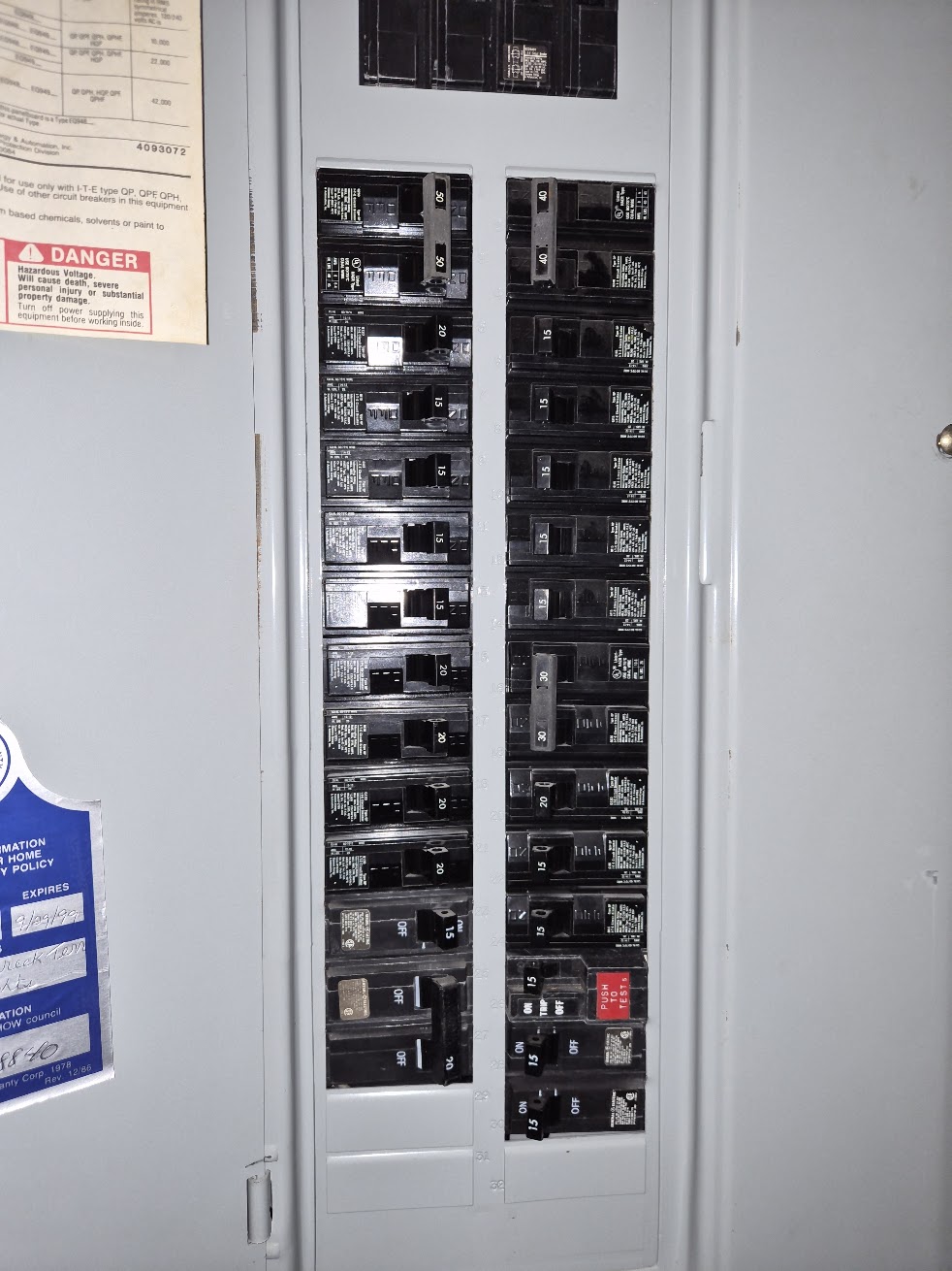 Circuit breakers beside a handwritten panel directory
