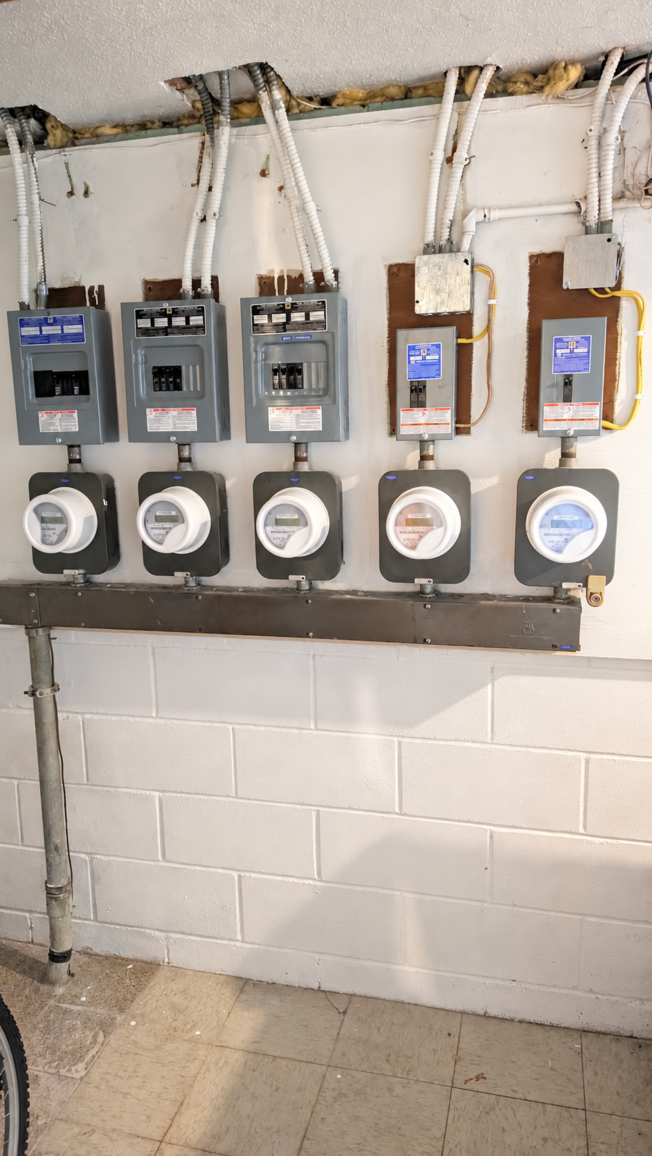 Three electrical panels with their matching electric meters below